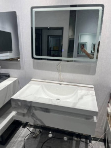 Modern White marblebathroom vanity featuring a cabinet a bowl sink and matching rectangular LED mirror