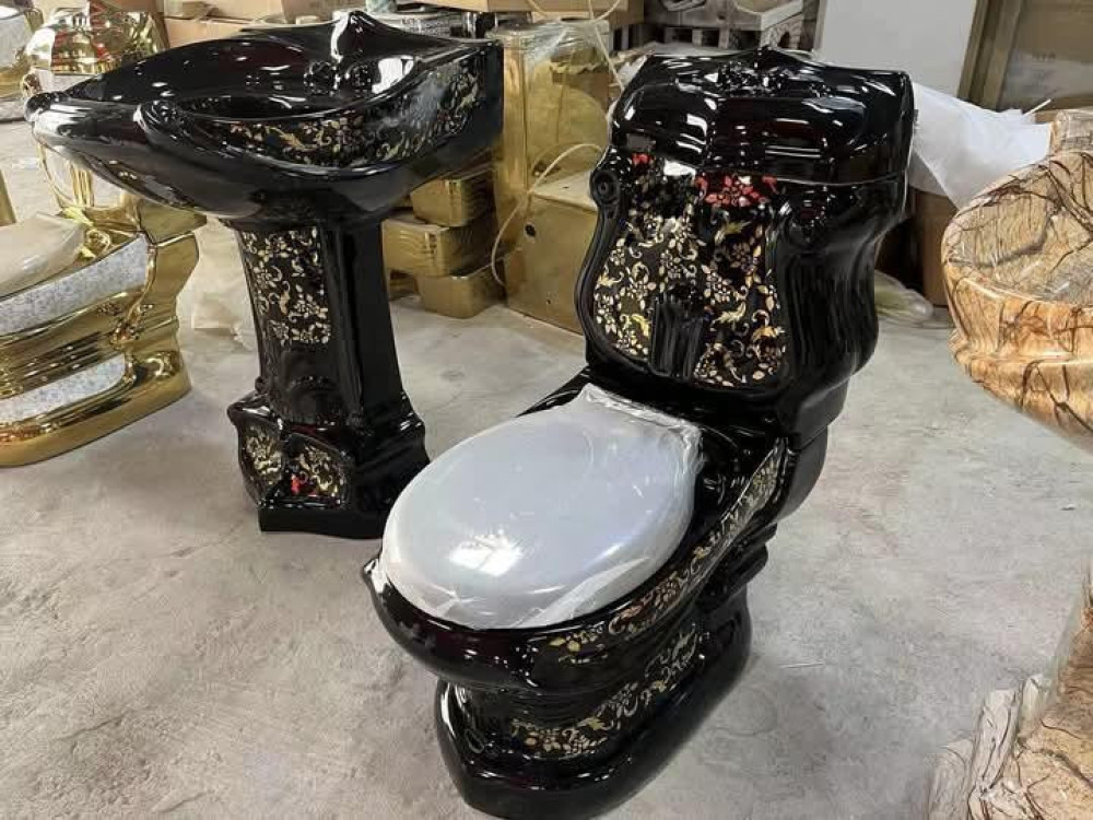 Features a luxury cermaic toilet and matching pedestal sink set in black with gold floral patterns