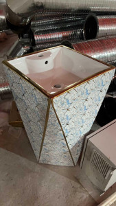 free-standing pedestal bathroom sink with a unique cracked marble-style finish and gold-toned accents